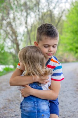 Kız ve erkek kardeş doğanın arka planına sarılıyor..