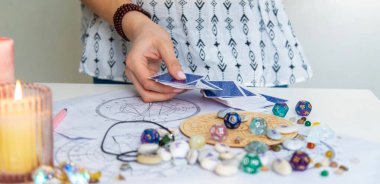 Bir falcı tarot kartlarıyla okur. Seçici odak.