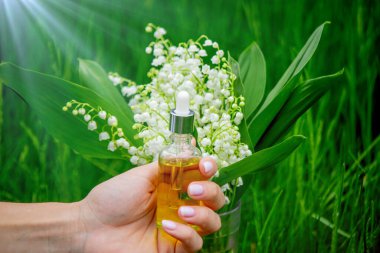 Cam bir şişe nilüfer çiçeği ve taze çiçekli gerekli yağ.