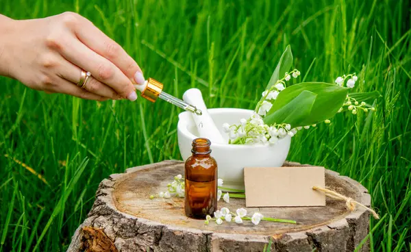 Cam bir şişe nilüfer çiçeği ve taze çiçekli gerekli yağ.