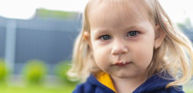 Küçük bir kızın burnundan süzülen mukus. Çocuğun sümüklü burnu akıyor, virüs gibi. Seçici odak.