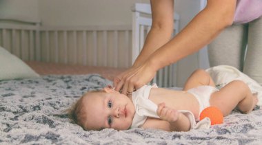 Anne üstünü değiştirip bebek için kıyafet giyer. Bebeğim.