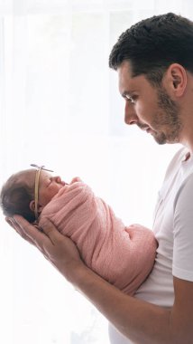 Bebeği kucağında tutan bir adam. Yeni doğan kavramı.