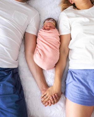 Bir adam ve bir kadın bebeklerine sarılıyor. Yeni doğan kavramı