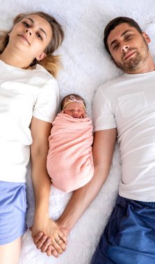 Bir adam ve bir kadın bebeklerine sarılıyor. Yeni doğan kavramı