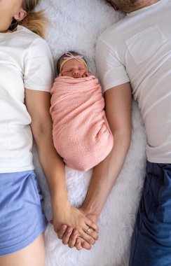 Bir adam ve bir kadın bebeklerine sarılıyor. Yeni doğan kavramı