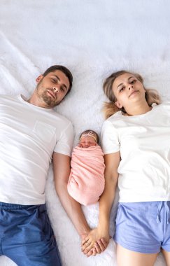 Bir adam ve bir kadın bebeklerine sarılıyor. Yeni doğan kavramı