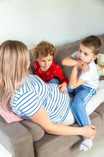 Hamile bir kadın oğlunu ve kızını kucaklıyor. Seçici odaklanma. Aşk.