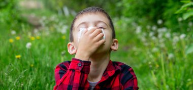 Çocuğun alerjisi var. Bir karahindiba üflüyor. Mevsimsel alerjiler. Burun akışı, sprey ve doku.