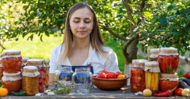Doğanın arka planında salatalık konservesi yapan bir kadın. Seçici odak.