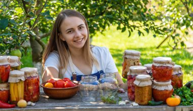 Doğanın arka planında salatalık konservesi yapan bir kadın. Seçici odak.
