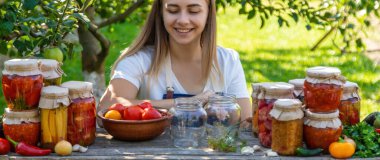 Doğanın arka planında salatalık konservesi yapan bir kadın. Seçici odak.