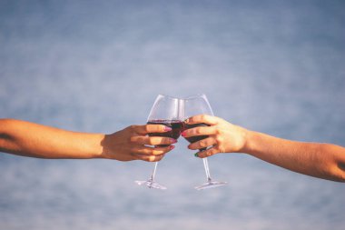 Deniz kenarında şarap içen iki kız..