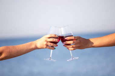 Deniz kenarında şarap içen iki kız..