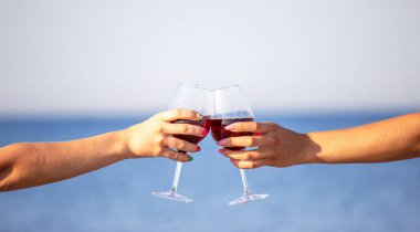 Deniz kenarında şarap içen iki kız..