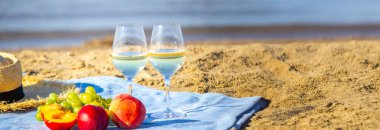 Denize karşı iki bardak şarap ve meyve.