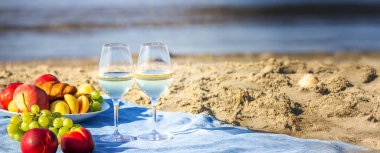 Denize karşı iki bardak şarap ve meyve.