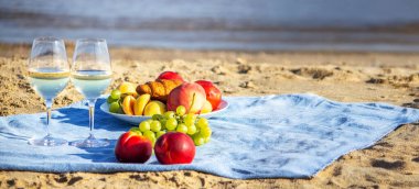 Denize karşı iki bardak şarap ve meyve.