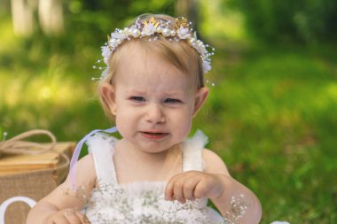 Küçük tatlı kız ilk doğum gününü kutluyor. Üzgün ve ağlıyor.