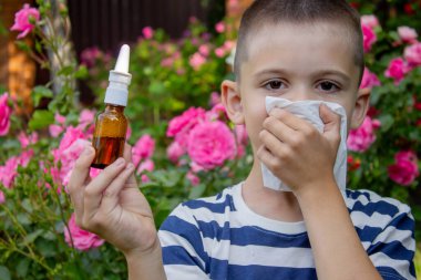 Çiçek alerjisinden hapşıran çocuk. Seçici odak.