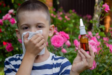 Çiçek alerjisinden hapşıran çocuk. Seçici odak.