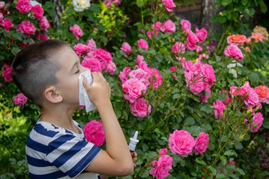 Çiçek alerjisinden hapşıran çocuk. Seçici odak.