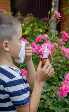 Çiçek alerjisinden hapşıran çocuk. Seçici odak.