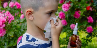 Çiçek alerjisinden hapşıran çocuk. Seçici odak.