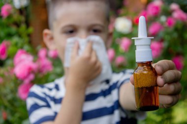 Çiçek alerjisinden hapşıran çocuk. Seçici odak.