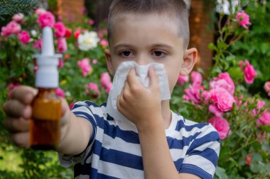 Çiçek alerjisinden hapşıran çocuk. Seçici odak.