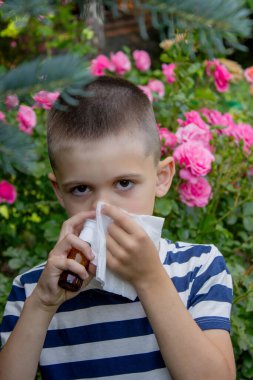 Çiçek alerjisinden hapşıran çocuk. Seçici odak.