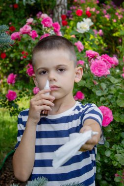 Çiçek alerjisinden hapşıran çocuk. Seçici odak.