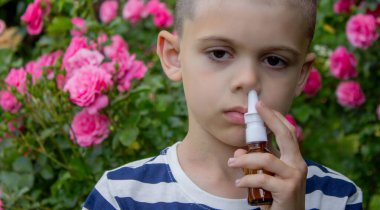 Çiçek alerjisinden hapşıran çocuk. Seçici odak.