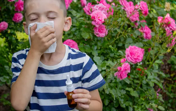 Çiçek alerjisinden hapşıran çocuk. Seçici odak.