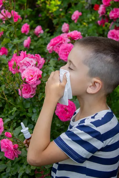 Çiçek alerjisinden hapşıran çocuk. Seçici odak.