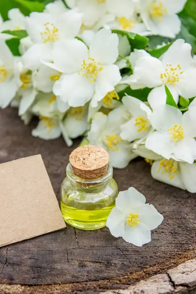 Cam şişede yasemin yağı ve yasemin çiçekleri. Yağlar