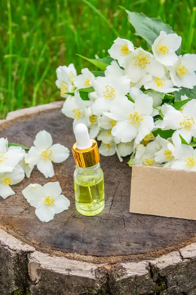 Cam şişede yasemin yağı ve yasemin çiçekleri. Yağlar