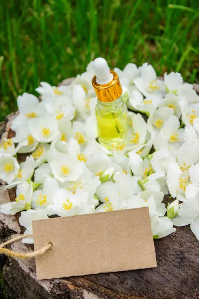 Cam şişede yasemin yağı ve yasemin çiçekleri. Yağlar
