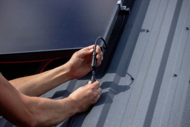 Metal Çatı Üzerine Teknisyen Güneş Panelleri Yükleniyor.