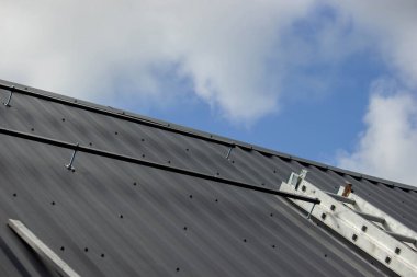 Bir adam çatıya güneş paneli monte ediyor. Seçici odak.