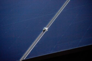 Bir adam çatıya güneş panelleri kuruyor. Seçici odak.