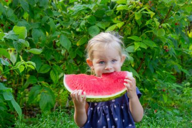 Sokakta karpuz yiyen mutlu bir çocuk. Yaz zamanı..