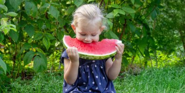 Sokakta karpuz yiyen mutlu bir çocuk. Yaz zamanı..