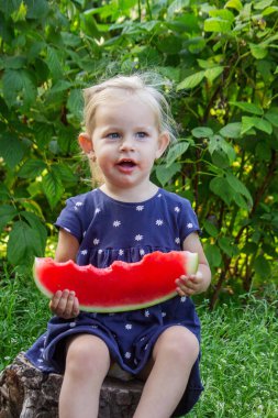 Sokakta karpuz yiyen mutlu bir çocuk. Yaz zamanı..