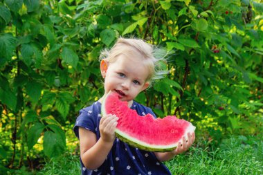 Sokakta karpuz yiyen mutlu bir çocuk. Yaz zamanı..