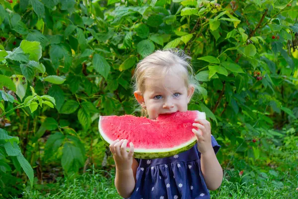 Sokakta karpuz yiyen mutlu bir çocuk. Yaz zamanı..