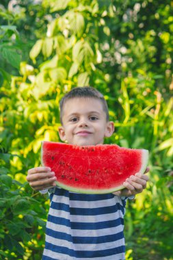 Mutlu çocuk karpuz yiyor. Yaz.