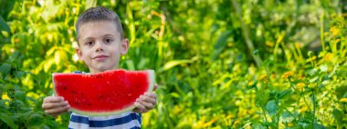 Mutlu çocuk karpuz yiyor. Yaz.