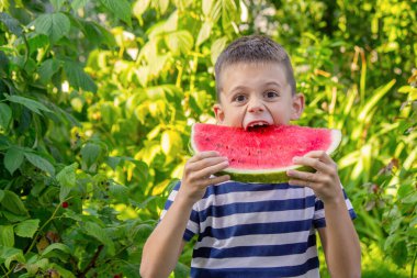 Mutlu çocuk karpuz yiyor. Yaz.