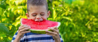 Mutlu çocuk karpuz yiyor. Yaz.